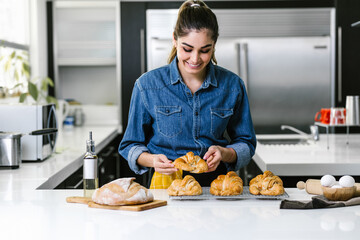 young Latin woman baking croissant ingredients in kitchen in Mexico Latin America