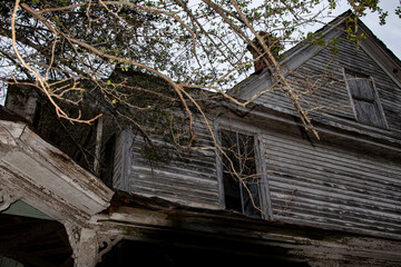 Abandoned dilapidated creepy wooden house looking up broken window