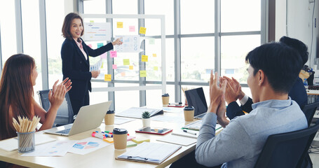 Group of business people meeting in conference room. Asian businessman speech, present teamwork partnership. Happy business people meeting present graph chart investment, business data in meeting room