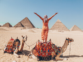 Girl on camel behind view in Sahara desert near Giza pyramids in Giza, Cairo, Egypt - obrazy, fototapety, plakaty