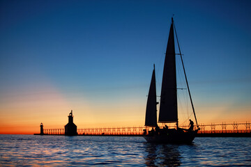 Sailing yacht at sunset, coming into the mouth of the river