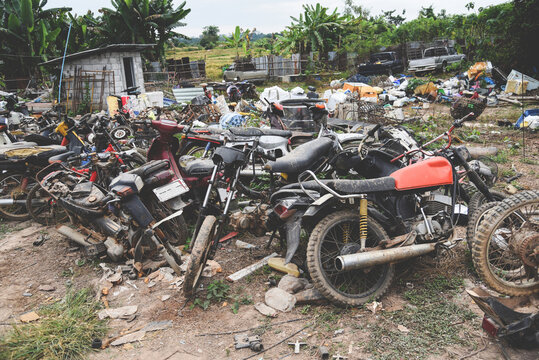 waste scrap with engine motorcycle old rust ,heap of old rusty metal wheel rims in the vehicle waste