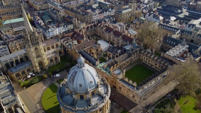 University of Oxford, sweeping aerial reveal passing the Church of Saint Mary the Virgin and the Radcliffe Camera Library. 