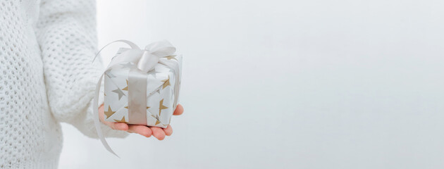 Female hands are holding small gift box. Winter holidays concept New Year Christmas. Selective focus, light background