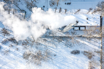 boiler-house with steaming chimney on chilly winter day. aerial top view from flying drone.