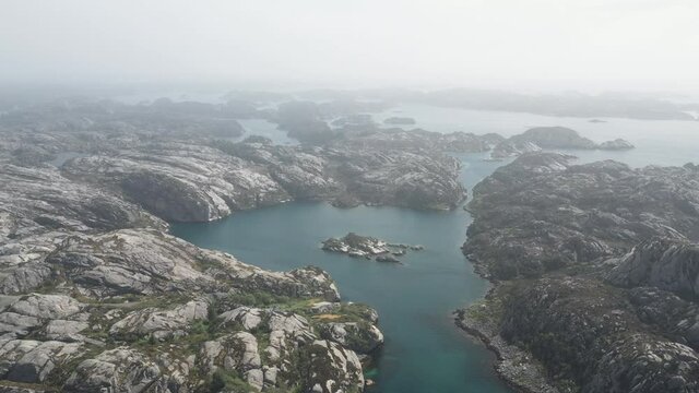 Aerial shot over fjord and islands west in Norway. Misty atmosphere.