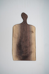 Handcrafted wooden walnut charcuterie serving board on a white background