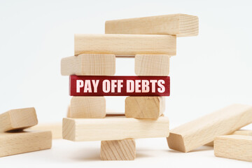 On the white surface there is a ruined tower made of planks, on a red plaque there is an inscription - Pay Off Debts