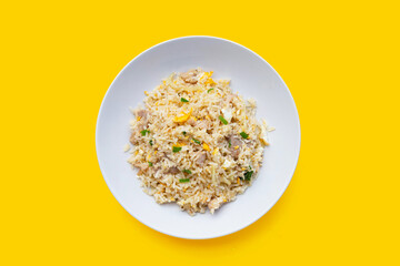 Fried rice in white plate on yellow background.