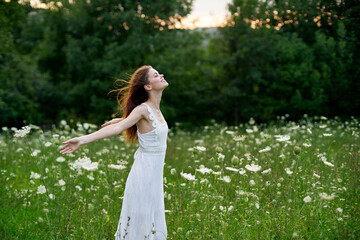 Woman in a white dress in a field on nature flowers freedom summer