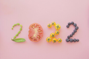 2022 made from healthy food and fruit on pastel pink background, New year health resolution, diet...