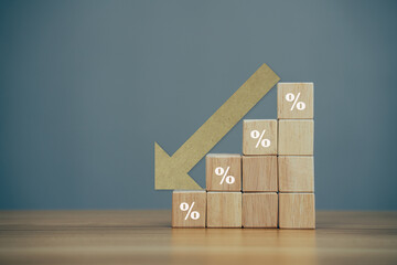 Wooden block with percentage sign and arrow down, problem in the economy.