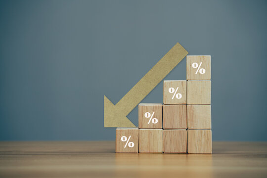 Wooden block with percentage sign and arrow down, problem in the economy.