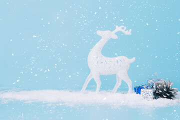 Christmas toy white deer star blue background, snow sparkles, confetti. Christmas or New Year card place for text.