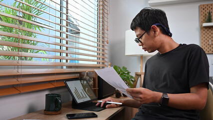 Young asian nab stock trader checking and analyzing financial graph on tablet computer.