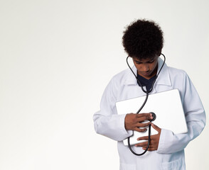 teenager disguised as a doctor with stethoscope, afro-Latino hair auscultates a laptop