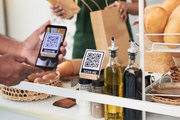 Customer scanning qr code with smartphone when receiving pick up order in cafe
