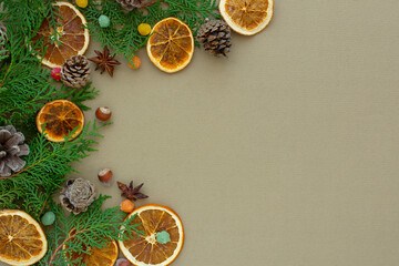 Fototapeta na wymiar Zero waste Christmas concept. Natural materials wood, paper, fir branches, cones, nuts, dried citrus fruits, cinnamon. Flat layout frame. Eco-greeting card in muted natural shades. New Year 2022 gifts