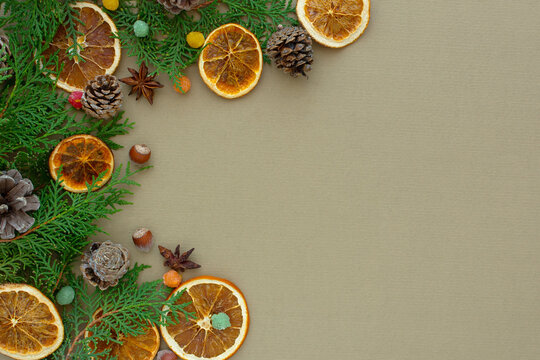 Zero waste Christmas concept. Natural materials wood, paper, fir branches, cones, nuts, dried citrus fruits, cinnamon. Flat layout frame. Eco-greeting card in muted natural shades. New Year 2022 gifts