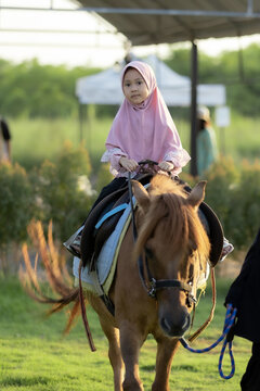 Portrait of Muslim girl riding horse 