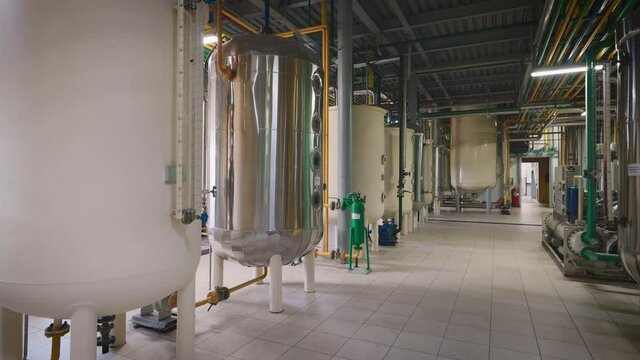 Shop of an industrial enterprise for the production of sunflower oil. The process of product refining takes place in special containers.