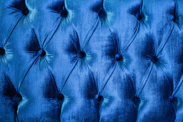 Blue velvet capitone textile, suede, velor, with buttons, sofa back. Close up texture