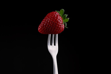 Photo of a strawberry on a fork.
Black Background