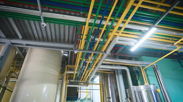 Complex piping. Multi-colored steel pipes are mounted under the ceiling.