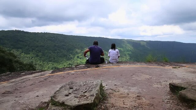 Jul,19,2019,Pakchong Thailand,Women and men sit and look at the mountain view at the cliffs of Khao Yai in Thailand