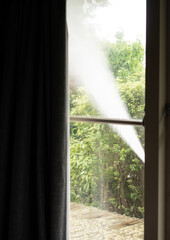 Jet of Water Spraying House Seen Through Window - Concept Cleaning Exterior Windows and Walls of House Vertical
