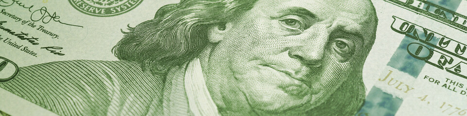 American paper money. A $100 bill with focus on eyes of Benjamin Franklin. US banknotes close-up....