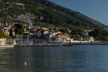 Fototapeta na wymiar Beautiful beach marina waterfront of Bol on Brac, old city with picturesque mountanious backdrop. View from harbor.