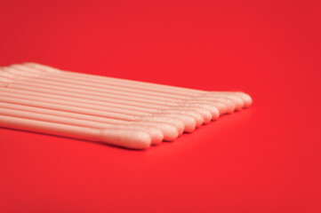 Cotton Buds isolated on bright red background. Close-up cotton buds. Selective focus.