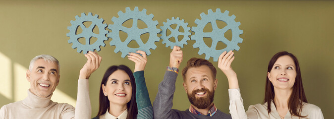 Part of system. Team of creative senior and young business people connecting gears on green banner...