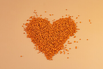 Heart shape with boxes of gifts on an orange background. The figurine is made of bright orange shiny beads. Valentine's day signs and symbols for copy space. Festive mockup.	