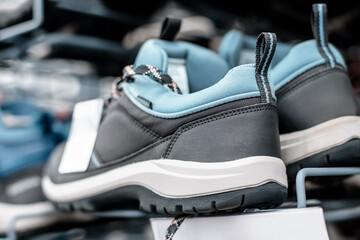 Modern hiking boots made of synthetic materials with a breathable and waterproof membrane on the store counter