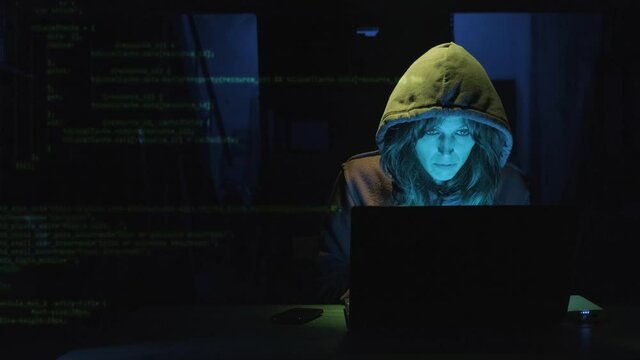 Woman Working On Laptop At The Table With Superimposed Computer Code. Cyber Attack Concept. medium shot, zoom-in