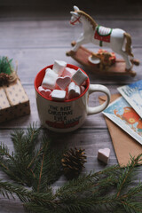 Cocoa with marshmallows, caramel candies, toys on a wooden photophone.