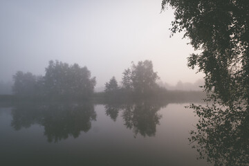 Fototapeta na wymiar Mist over a lake with trees