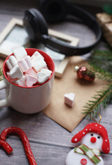 Cocoa with marshmallows, caramel candies, toys on a wooden photophone.