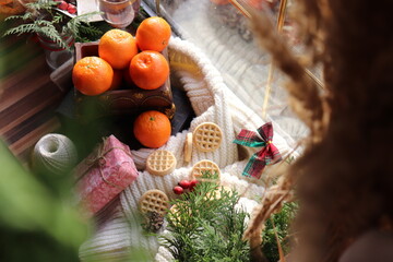 christmas closeup on the window, place for text, wood, cookies and red globes, fir branches, clementines, oranges, christmas vibe, small moments, celebration.