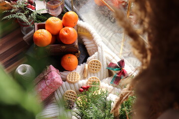 Fototapeta na wymiar christmas closeup on the window, place for text, wood, cookies and red globes, fir branches, clementines, oranges, christmas vibe, small moments, celebration.
