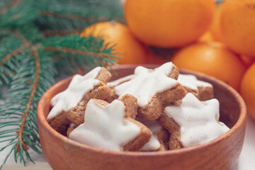 Winter background with Christmas tree branches, cones, Christmas toys, cookies and tangerines, with white space 