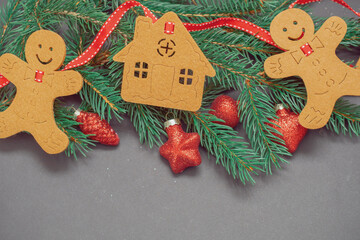 Winter background with Christmas tree branches, cones, Christmas toys and Christmas cookies, with black space for replicas