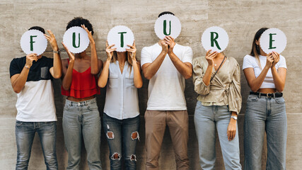 Young people hiding faces behind the word 'Future' - Concerns and prospects for new generations - Concept of youth questioning their future. - obrazy, fototapety, plakaty
