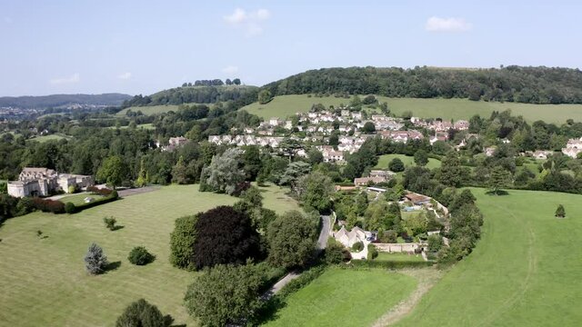 AERIAL - Stouts Hill, houses and hills in Uley, Cotswolds, England, pan left