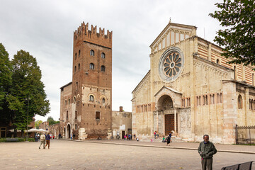 Few tourists and passersby walk near the Basilica di San Zeno Maggiore  in Verona, Italy.