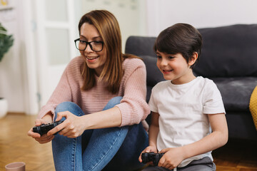 mother and son playing video games at home