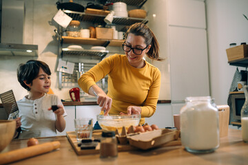 mother and her son preparing food together in kitchen