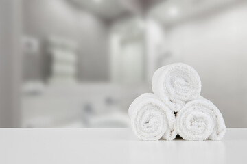 Obraz na płótnie Canvas Stacked white spa towels on table against blurred background